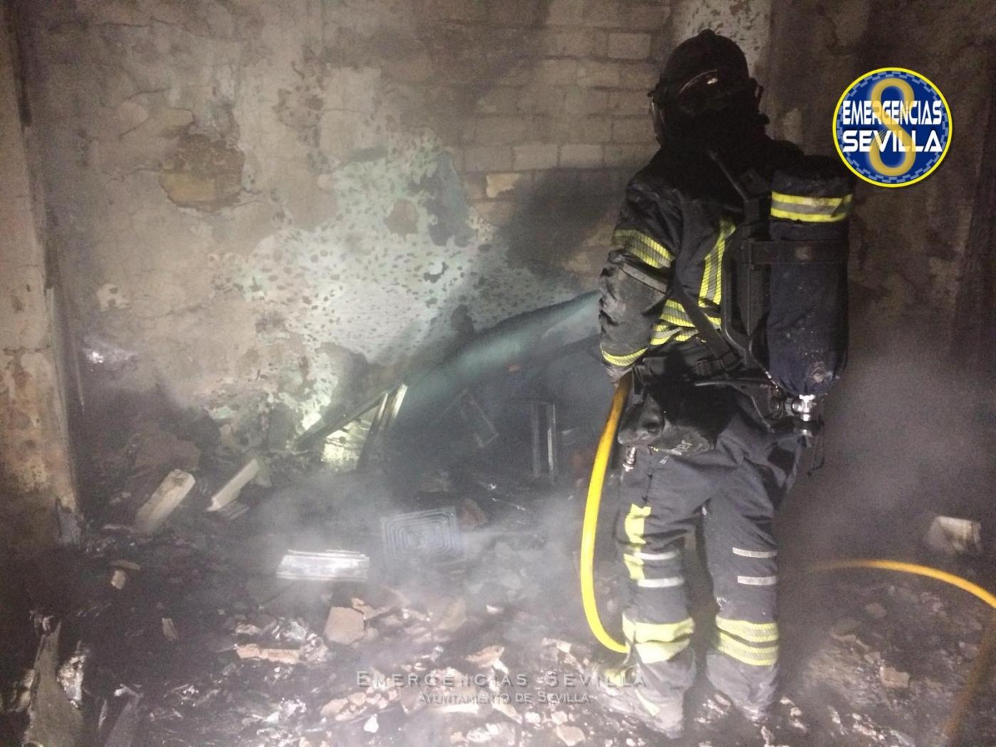 Un bombero realiza su trabajo en la vivienda incendiada. - Emergencias