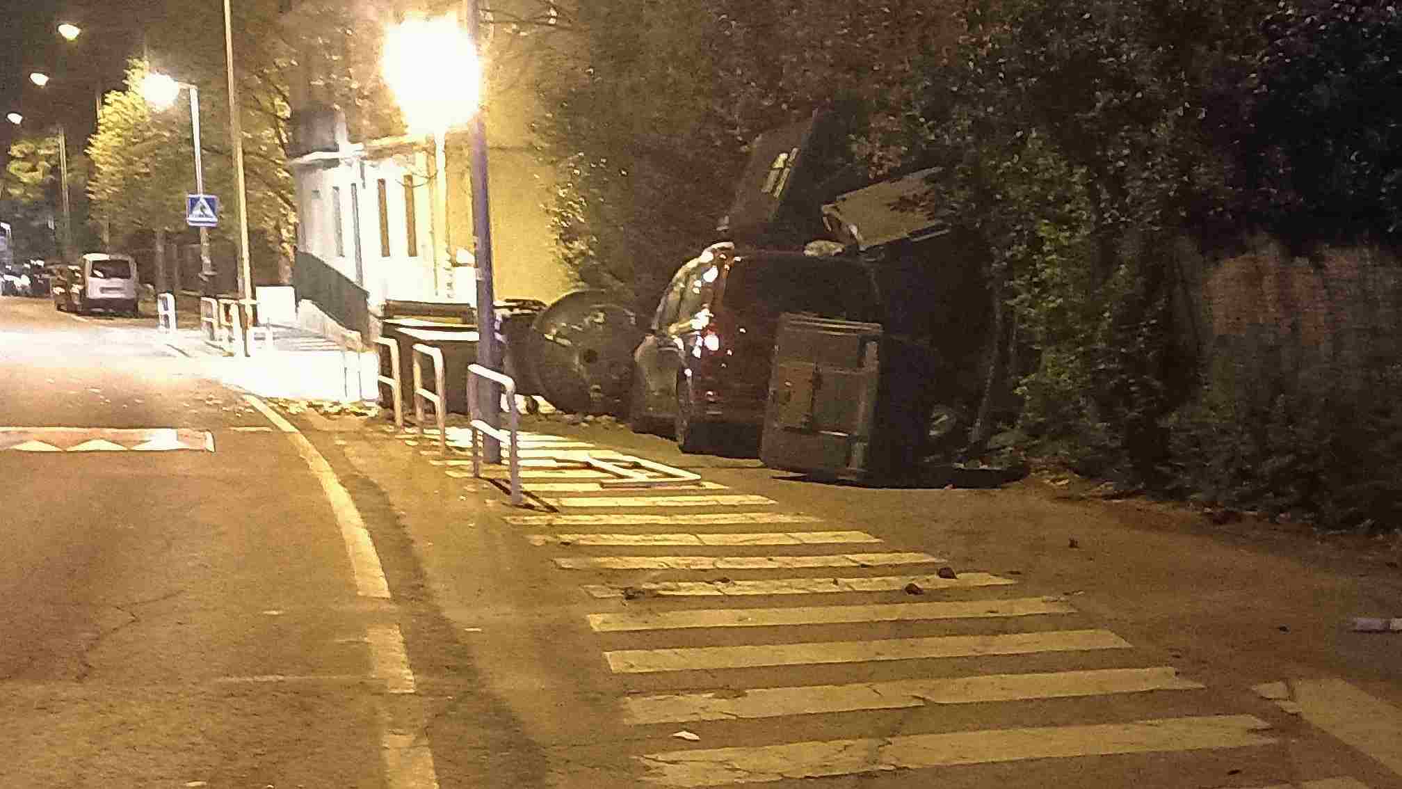 Espectacular accidente de un conductor en Pamplona: acaba con un contenedor en el techo del coche