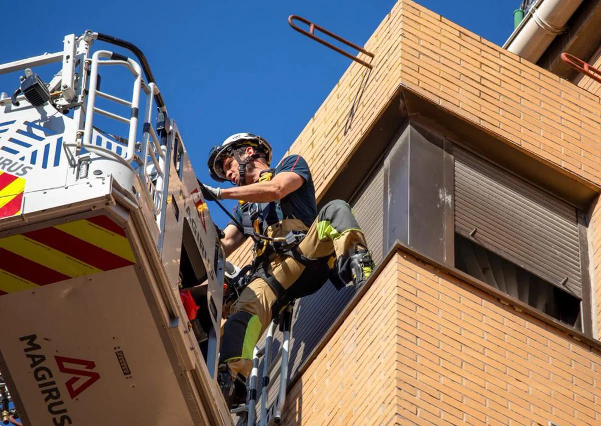 Imagen secundaria - Los Bomberos de Burgos trabajan para acceder a una casa por la ventana.