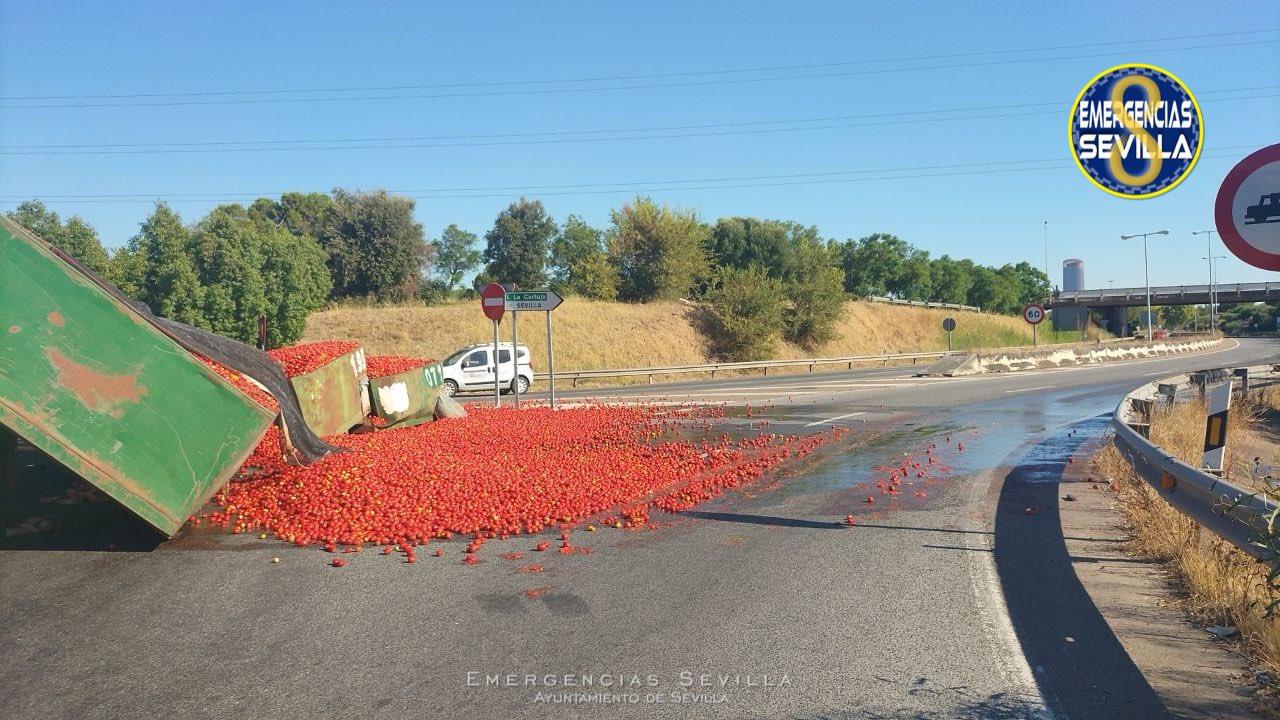 Un camión vuelca su carga de tomates en la carretera SE-20, cerrando un carril en Sevilla.
