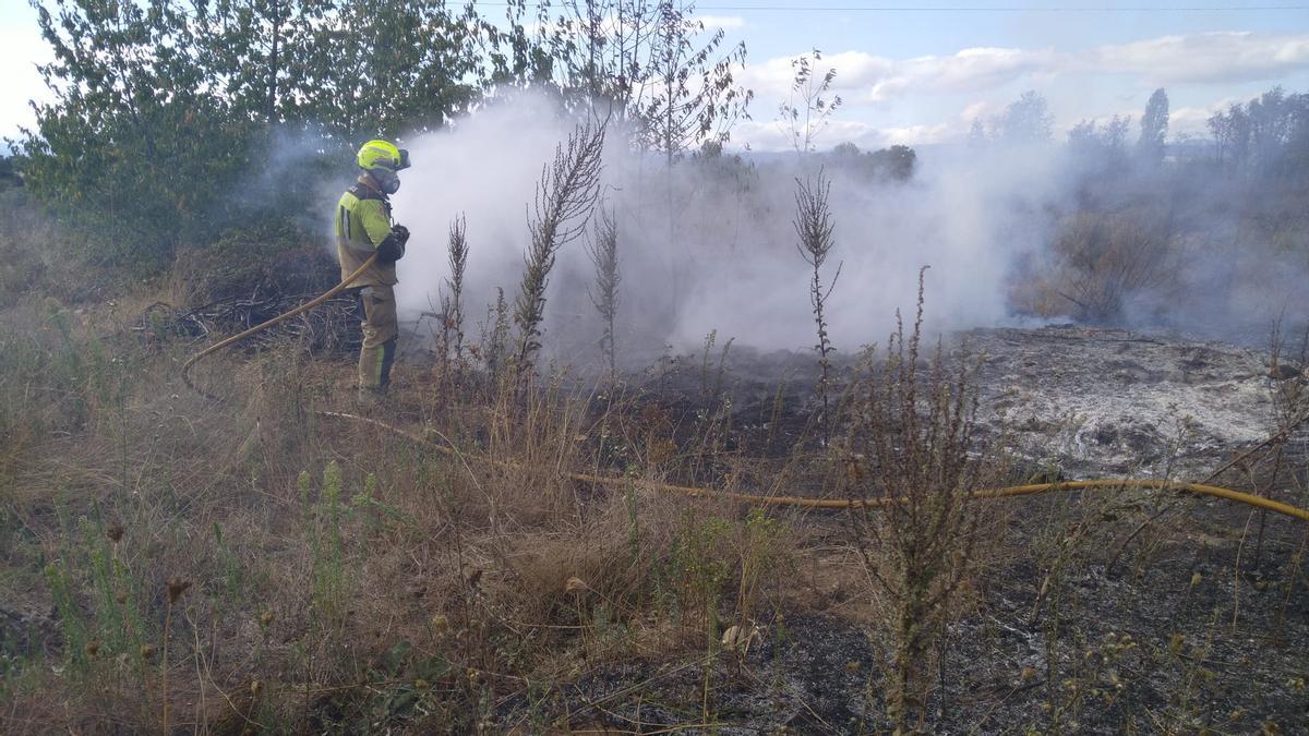 Bomberos de la Junta y Ponferrada trabajan para sofocar un incendio que puso en peligro una vivienda en La Placa