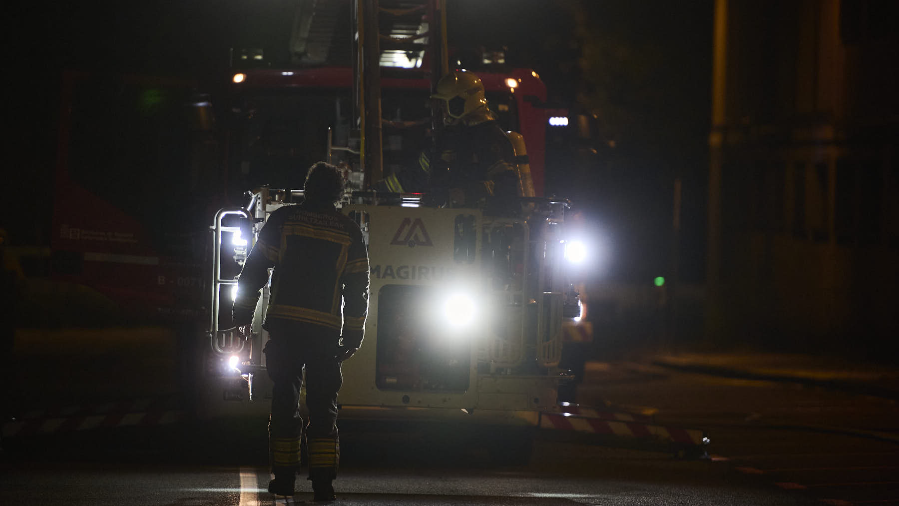 Los bomberos trabajan por la noche en la extinci&oacute;n de incendio originado en las dependencias de la Polic&iacute;a Municipal de Pamplona. PABLO LASAOSA