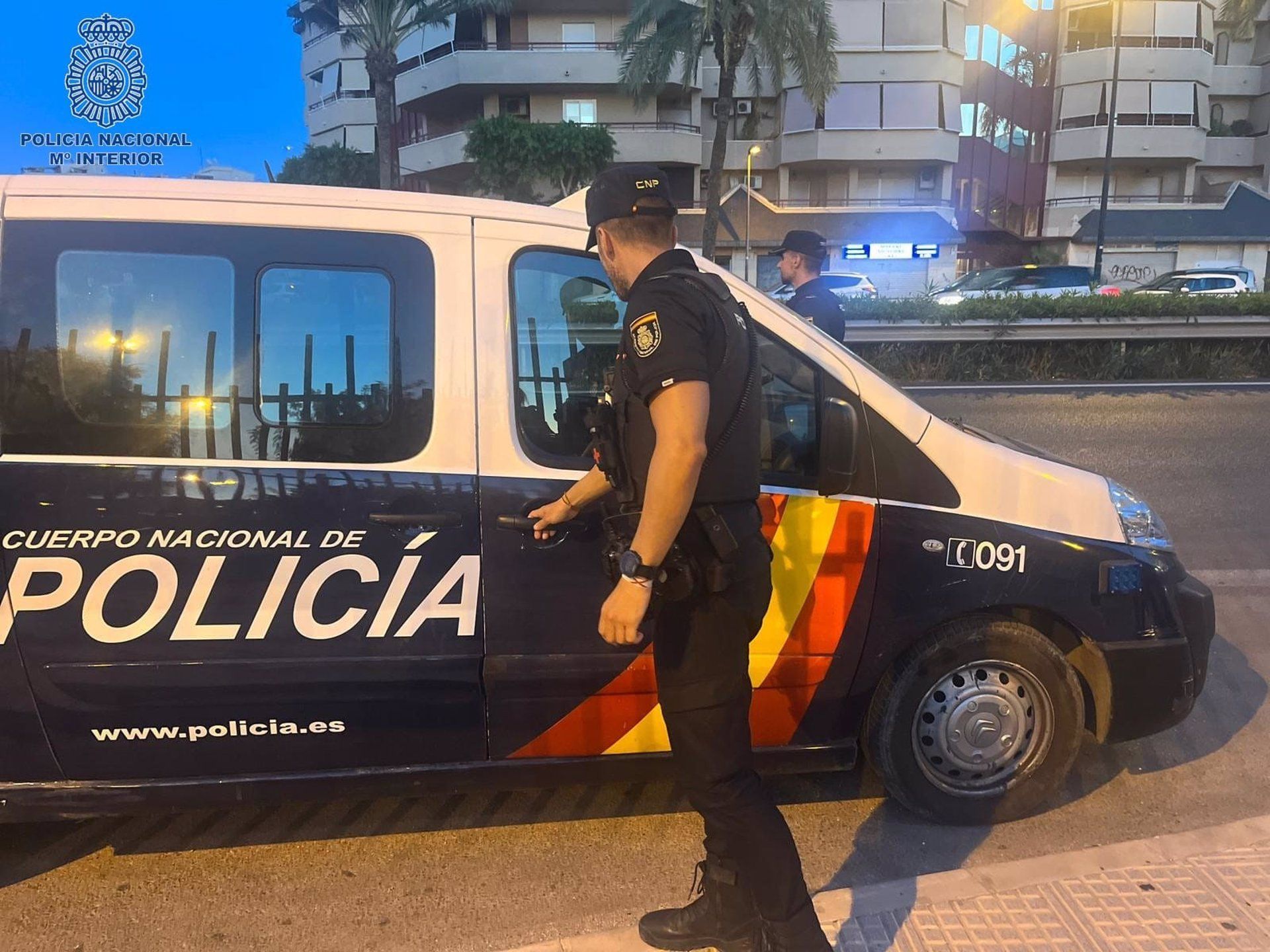 Un agente de la Policía Nacional junto a un furgón.   POLICÍA NACIONAL. Archivo