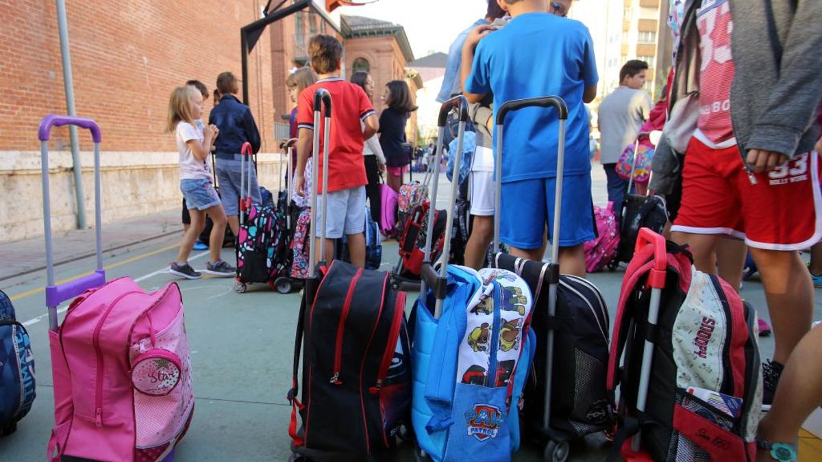 Imagen de archivo de niños esperando la entrada a un colegio.