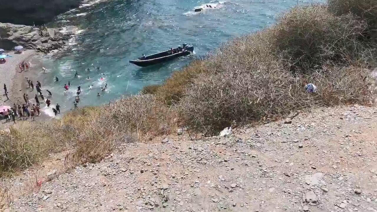 Una patera desembarca en Cala del Barco, en Cartagena, ante la sorpresa de los bañistas